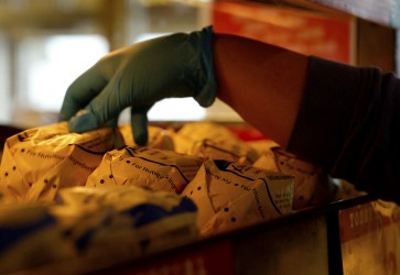 Hand grabbing packaged sandwich